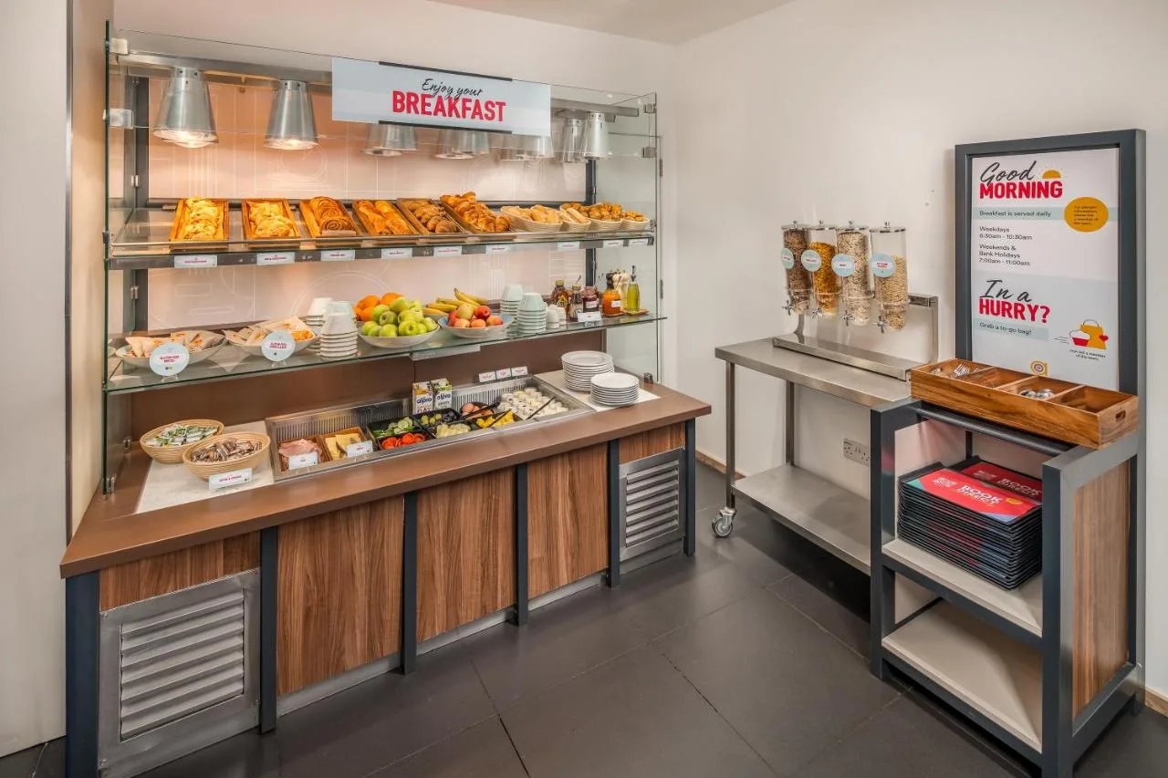 a bakery with a counter with different types of food at Point A Hotel Glasgow in Glasgow